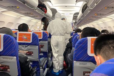 Contrôle d'un passager à bord d'un avion qui vient d'atterrir à Shanghai, en provenance de la province où l'essentiel des cas d'infections sont répertoriés, samedi.