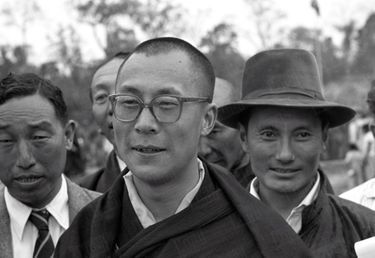 Traqué par les Chinois, le 14e Dalaï Lama a fuit le Tibet et trouvé refuge en Inde. Le 18 avril 1959, il arrive à la frontière de l'Assam, après avoir traversé la région des territoires de la North East Frontier Agency (NEFA) qui sépare l'Inde du Tibet et de la Chine. Avant de rejoindre la ville de Tezpur où lui et ses partisans sont attendus par la presse internationale, il fait quelques pas pour saluer le comité d'accueil venu l'attendre à la frontière. Derrière lui, coiffé de son chapeau, Gyalo Thondup, un de ses frères aînés.