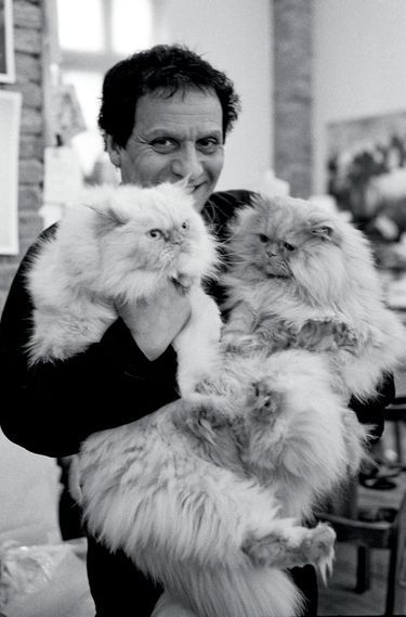 Le couturier et deux de ses chats chez lui, à Paris, en 1998