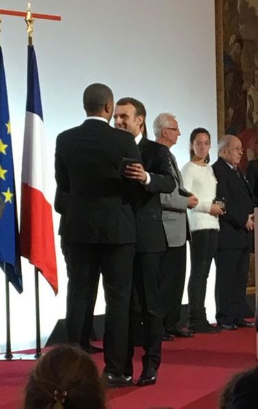 Emmanuel Macron salue Thibault Bagoe-Fresino, pupille de la nation, à qui il remet la médaille du centenaire des pupilles.
