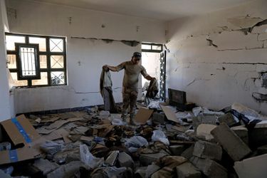 Un soldat irakien découvre des uniformes de militants de Daech dans un appartement dévasté.