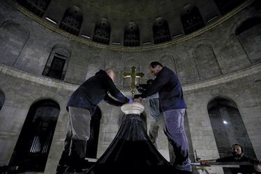Installation d’une croix byzantine au faîte de l’édifice. Elle ne fait pas l’unanimité parmi les Eglises.