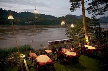 A Luang Prabang, la rive est constellée de petits restaurants à ciel ouvert où l’on vient regarder le soleil se coucher