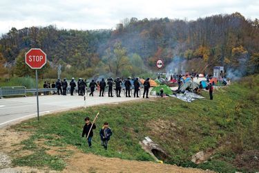 Face aux policiers bosniaques, le camp improvisé des migrants.
