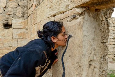 Fryal, 18 ans, embrasse le serpent noir, symbole de la sagesse, au temple de Zewa Name Sivan, un lieu saint yézidi, le 15 novembre. Emprisonnée à Kotcho, elle a assisté à des ventes de femmes. La plus jeune avait 8 ans.