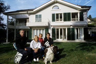 Charles Aznavour, Ulla, leurs deux fils Micha (15 ans) et Nicolaï (10 ans) et Twiggy, un English Springer Spaniel devant la maison de Cologny, en Suisse, le 25 septembre 1987.