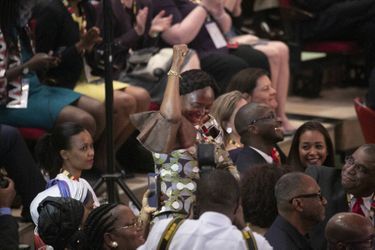 Au milieu de la cérémonie, Lucia, l'amie d'Ellen Johson Sirleaf, se lève sous le regard complice d'Adama Sirleaf (à Dte), le fils de l'ancienne présidente du Liberia et médecin urgentiste aux Etats-Unis