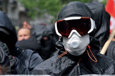 La tenue de combat : capuche, T-shirt noué autour de la tête, coupe-vent noir, lunettes de ski ou de piscine, masque à gaz.