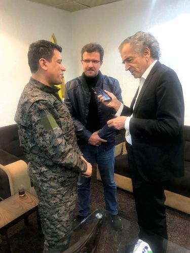 Conversation téléphonique entre le président Macron, Mazloum Abdi, le chef militaire kurde syrien dont la tête est mise à prix par la Turquie, et BHL. Au milieu, l’interprète.