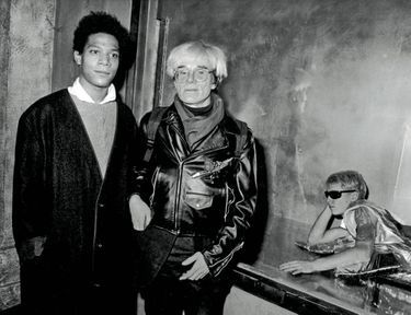 Avec Andy Warhol en septembre 1984 au night-club l’Area à New York, lors d’une exposition au bénéfice de l’Académie de musique de Brooklyn. Affiche pop art des deux artistes en gants de boxe pour une exposition commune à New York, en 1985.