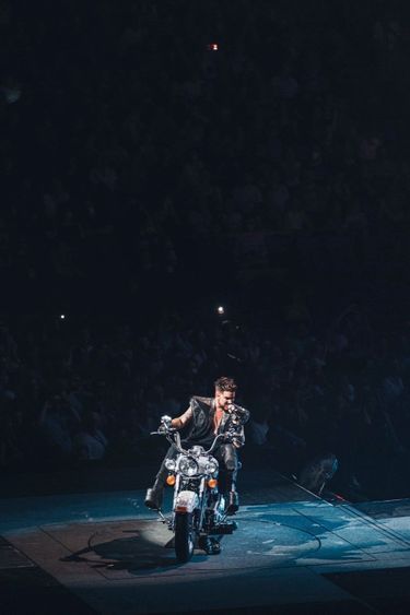 Adam Lambert sur un moto apparue dans la salle.