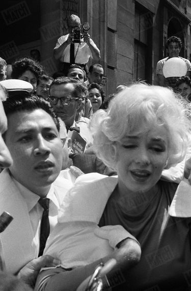 En juillet 1961, Marilyn Monroe quitte le Polyclinical Hospital de Manhattan, après avoir subi l'ablation de la vésicule biliaire. Tantôt souriante, tantôt apeurée, amaigrie et fragilisée (elle sort dans un fauteuil roulant, avant de se lever), elle est cernée par la foule et les photographes.