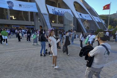 Une fan de BTS pose devant le stade de Busan quelques heures avant le début du concert, ce samedi.
