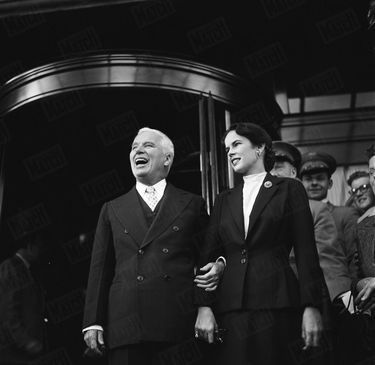 Charlie Chaplin et son épouse Oona acclamés par la foule devant le Savoy Hotel de Londres, en septembre 1952.