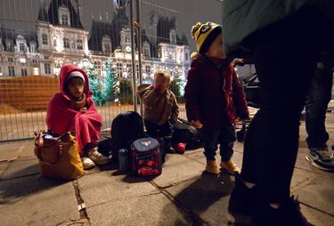 Une famille récemment venue de Géorgie avec trois enfants attend place de l’hôtel de ville une solution de logement pour la nuit, le 1er décembre 2022.