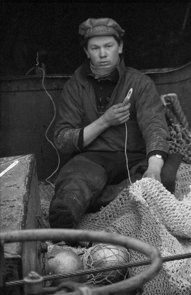 L’un des pêcheurs du « Godefroy-de-Bouillon » répare un filet.