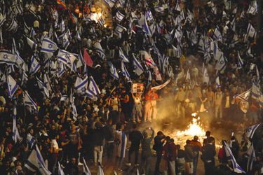 L’opposition démocratique brandit le drapeau israélien après le limogeage du ministre de la Défense qui appelait à une pause d’un mois dans la réforme des institutions, le 26 mars à Tel-Aviv. Le lendemain, le gouvernement cède à la pression.