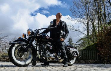 En Harley Davidson, l’une des nombreuses motos de sa collection.