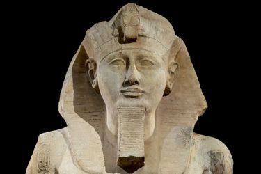 Le visage du colosse de Ramsès II avec ses attributs pharaoniques : un némès -coiffe-, une barbe postiche et cobra sur le front.