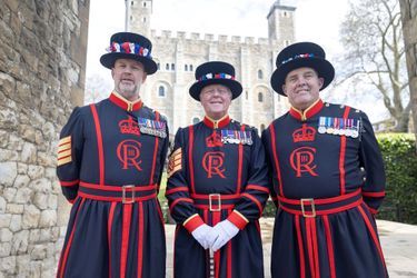 Trois Yeoman Warders de la Tour de Londres -dont le chef Pete McGowran au centre- arborent leur nouvel uniforme aux initiales du roi Charles III, le 24 avril 2023