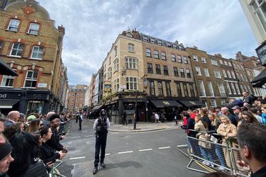 Les fans attendent patiemment l'arrivée du prince William et Kate Middleton devant le pub Dog and Duck, dans le quartier de Soho à Londres, le 4 mai 2023.