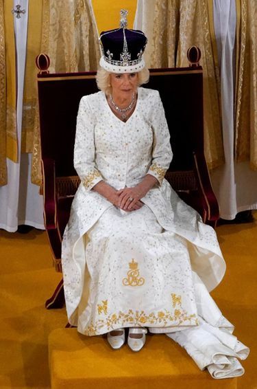 La reine Camilla dans sa robe-manteau de couronnement, le 6 mai 2023. En bas de la robe, la frise des fleurs emblèmes des quatre nations est surmontée de la représentation de ses deux chiens