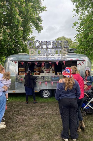 Food trucks proposent bières et cafés, burgers et donuts, aux nombreux spectateurs réunis dans le parc du château de Windsor. Le 7 mai 2023.