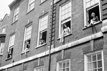 En juin 1966, Mary Quant (au centre) pose avec quatre mannequins en minijupe, depuis les fenêtres de son appartement situé dans une ancienne école de danse du quartier de Chelsea, à Londres.