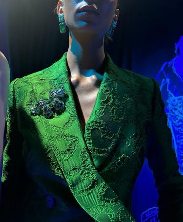 Signée Caroline’s Couture, une veste à motifs coeurs, des boucles d’oreilles en émeraudes et une broche papillon en titane et pierres multicolores.