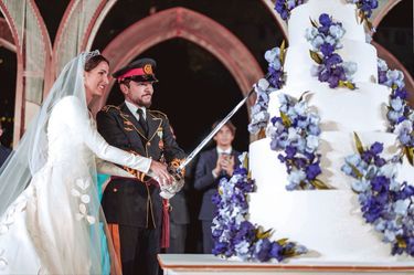 Le couple princier découpe son gâteau de mariage à l’aide d’une épée, comme le veut la tradition.