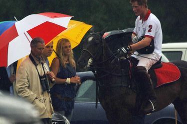 Le prince Harry à cheval, sous le regard de son père Charles et de sa petite amie Chelsy Davy, à Cirencester, le 22 juillet 2006.