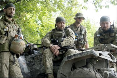 À gauche, Ruslan. Sur le véhicule, Vladimir, ancien garagiste de Kharkiv, qui ne quitte plus son AK-47 à lunette