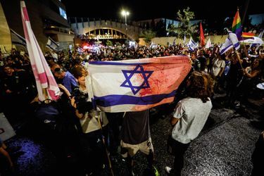 Il brandit une bannière ensanglantée : un drapeau coupé en deux à l’image du pays. À Jérusalem.
