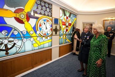 La reine Camilla au RAF Club à Londres devant le vitrail inauguré par sa belle-mère la reine Elizabeth II en 2018, le 29 août 2023