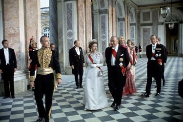 Précédés par le chef du protocole, la reine Elizabeth et le président Pompidou, suivis par Claude Pompidou et le prince Philip, dans le péristyle du Grand Trianon lors de la soirée de gala de 1972.