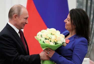Russia's President Vladimir Putin presents flowers to editor-in-chief of Russian broadcaster RT Margarita Simonyan after awarding her with the 