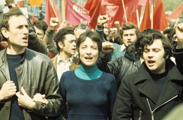 Paris - 1er mai 1974 - Lors des manifestations, devant des drapeaux rouges, un cortâÂ®ge de personnes se tenant par le bras, avec ââ  sa tââ¢te, portant un pull bleu, la porte-parole de LUTTE OUVRIERE Arlette LAGUIL