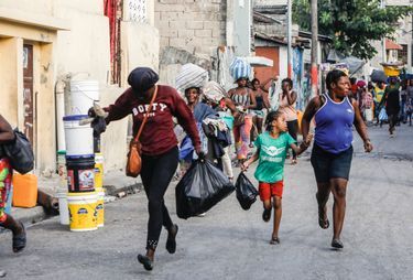 Â© Corentin Fohlen/ Divergence. Port-au-Prince, Haiti. 19 mars 2024. Dans le quartier de Bel Air, dans la capitale haitienne, manifestation du mouvement reuni des gangs, Viv Ansam. # Suite a des tirs de la police, des hommes en armes se defendent.