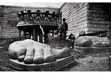 Les pieds et un éléments de la torche de la statue de la Liberté, posés sur le sol à côté de son piédestal à New York. Photo non datée