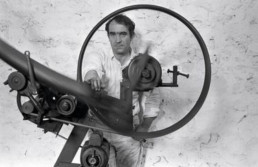 The sculptor Jean Tinguely in May 1965. in his workshop in the Dannemois commandery (Essonne), in front of one of his mobile machines. niki de saint phalle jean