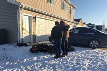 Devant la maison de la famille retrouvée morte samedi, des proches se recueillent.