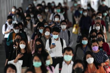 Des passagers portent un masque dans une station de train de Bangkok.