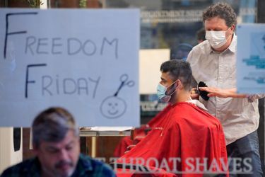Un barbier retrouve ses clients après la fin du confinement à Melbourne.