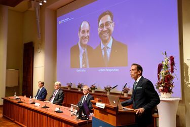 Thomas Perlmann, le secrétaire du Comité Nobel, se tient à côté d'un écran affichant les lauréats du Prix Nobel de médecine 2021, David Julius et Ardem Patapoutian, lors d'une conférence de presse à l'Institut Karolinska de Stockholm.