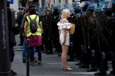 Une femme devant les forces de l'ordre lors de la manifestation samedi à Paris.