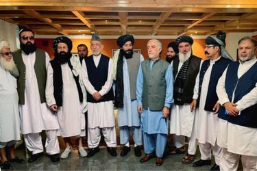 L'ex président Hamid Karzaï (en toque) et l'ancien chef de l'exécutif Abdullah Abdullah (nu-tête) avec les représentants talibans de la commission de "transfert pacifique du pouvoir", le 19 août.
