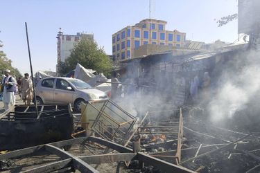 De la fumée s'échappe des magasins endommagés après les combats entre les talibans et les forces de sécurité afghanes dans la ville de Kunduz, au nord de l'Afghanistan, le 8 août 2021