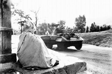 En 1956, un blindé de l&#039;armée française traverse un village algérien. 
