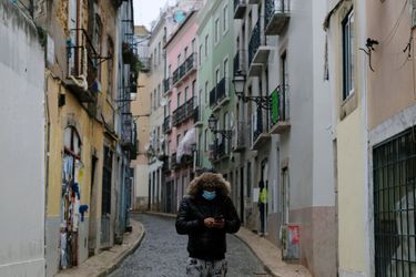 Un homme masqué marche seul dans une rue vide du Portugal. 
