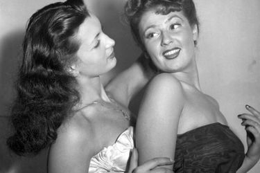 Juliette Figueras, Miss France 1949 (en robe blanche), en compagnie de sa première dauphine Colette Deréa, le soir de son élection, le 21 décembre 1948, au cabaret &quot;Le Tyrol&quot;, à Paris.